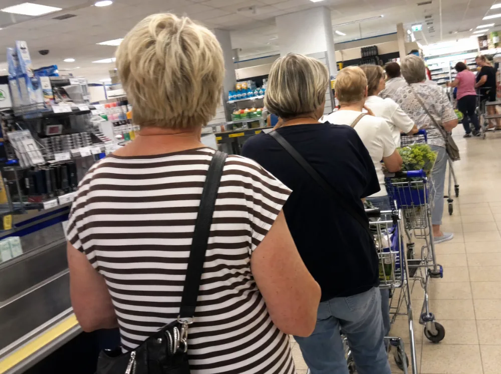 Frauen über 50 in der Warteschlange an einer Supermarktkasse