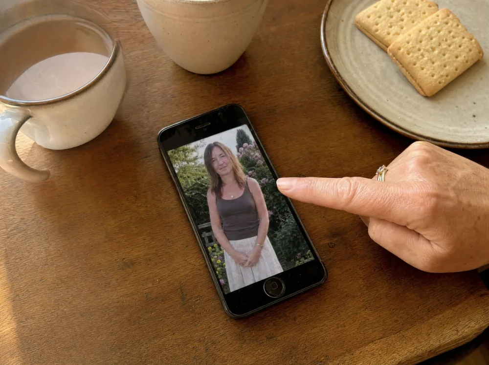 Handy auf dem Küchentisch mit altem Foto einer Frau mit dünnem Haar